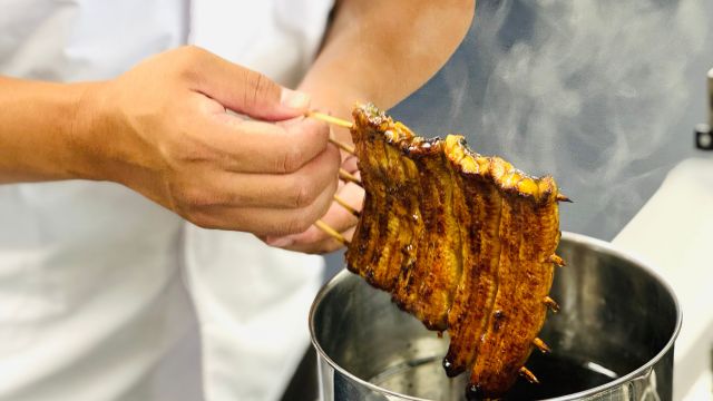 ウナギの蒲焼きを職人が調理している様子